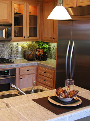 ceramic tile countertops on kitchen peninsula and cabinets